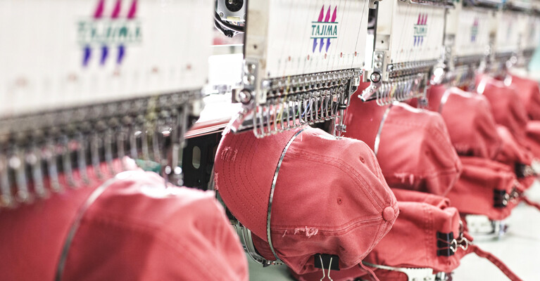Hats being stitched by embroidery machines.