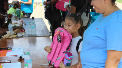 A child receiving a new backpack.