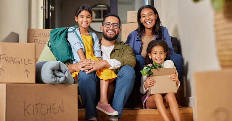 A family surrounded by moving boxes.