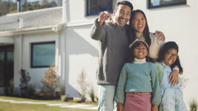 A family in front of their new home.