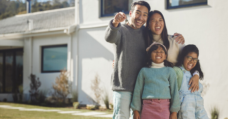 A family in front of their new home.