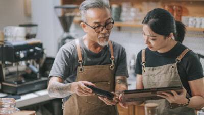 Two small business employees looking at a tablet together.