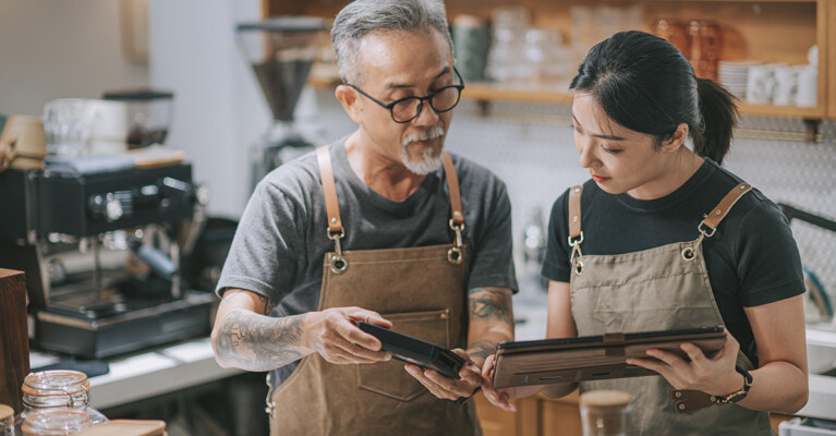 Two small business employees looking at a tablet together.