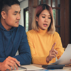 A man and a woman sitting to discuss their finances.