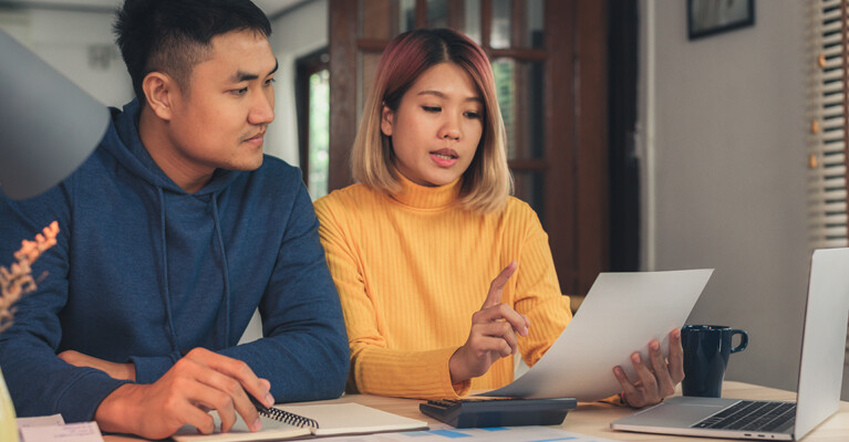 A man and a woman looking at documents.