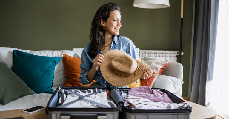 A woman packing a suitcase for vacation.