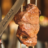 A piece of steak being cut with a knife.